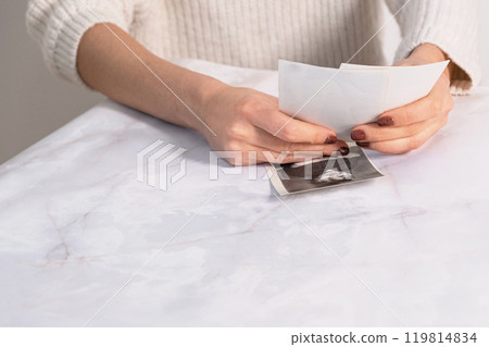 woman sitting at desk and looking at printed photos, remember nostalgia for a day of rest. photography cards, background. Mock up woman sitting at desk and looking at printed photos, remember nostalgia for a day of rest. photography cards, background. Mock up 119814834