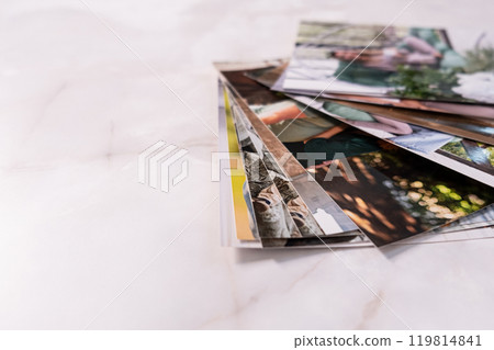 woman sitting at desk and looking at printed photos, remember nostalgia for a day of rest. photography cards, background. Mock up 119814841