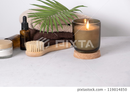 Skin care product for oil face massage and flowers on white table. Eco friendly organic reusable self care accessories. 119814850