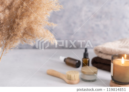 Selective soft focus. Skin care product for oil face massage and flowers on white table. Eco friendly organic reusable self care accessories. 119814851