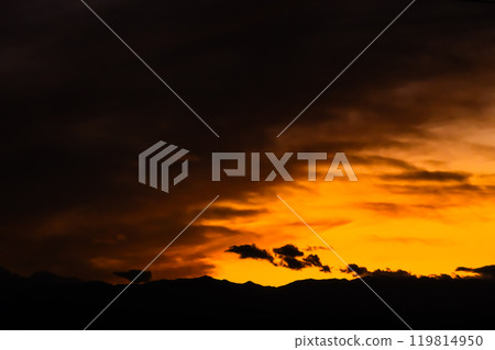 Autumn evening sky, clouds covering the western sky and silhouettes of mountains, high saturation contrast Autumn evening sky, clouds covering the western sky and silhouettes of mountains, high saturation contrast 119814950