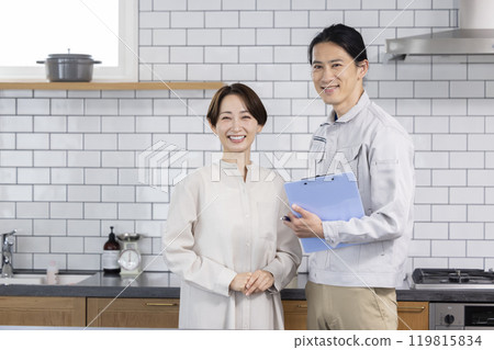一個穿著工作服的男人和一位家庭主婦一起諮詢房屋改造 119815834