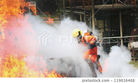 Firefighter fighting smoke flame use fire hose chemical water foam spray engine. Firefighter Rescue training in fire fighting extinguisher. Fireman wear hard hat safety suit uniform for protection 119816488