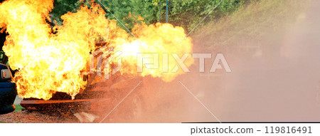 Firefighter Rescue training in fire fighting extinguisher. Firefighter fighting with flame using fire hose chemical water foam spray engine. Fireman wear hard hat, safety suit uniform for protection Firefighter Rescue training in fire fighting extinguisher. Firefighter fighting with flame using fire hose chemical water foam spray engine. Fireman wear hard hat, safety suit uniform for protection 119816491