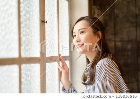 Woman looking out the window 119816610
