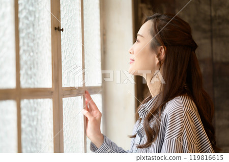 Woman looking out the window 119816615