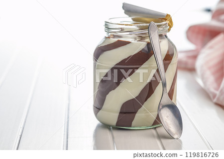 Chocolate cream spread in jar on white table. 119816726