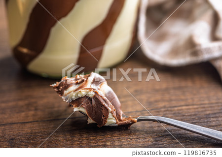Chocolate cream spread in spoon on wooden table. Chocolate cream spread in spoon on wooden table. 119816735