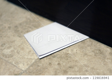 Letter envelope slipped under the door. Secret information from an anonymous person. Information for residents under the door 119816941