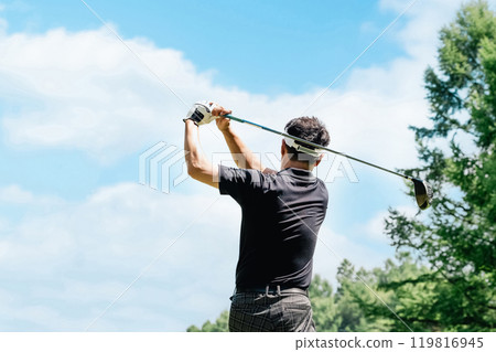 Male golfer hitting a driver shot on a golf course 119816945