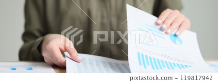 Manager checkups papers with business statistics in office Manager checkups papers with business statistics in office 119817942