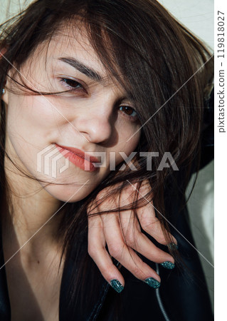 Portrait of a beautiful fashionable slender woman in a black leather jacket 119818027