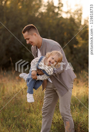 Father holding happy child on summer walk in park. 119818733