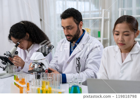 Scientist team in white laboratory coat working with microscope and laptop for research in scientific research laboratory . 119818798