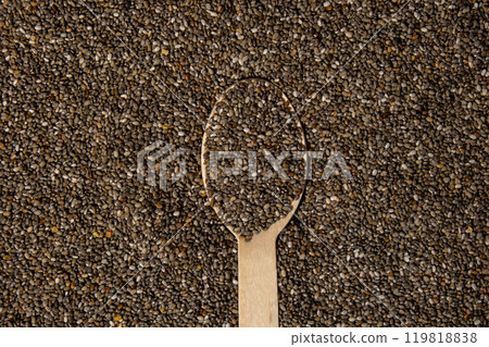 Chia seeds in wooden spoon. Healthy superfood rich in Omega 3 fatty acids. Dry healthy natural ingredient. Chia grains are falling 119818838
