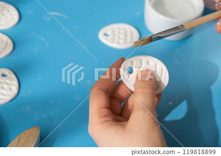 Creator is using white air dry clay for making decor to EASTER holiday. Creating hobby recreation activity that involves fingers. DIY crafting 119818899