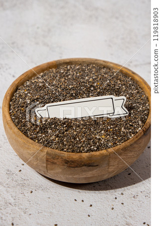 Chia seeds in wooden bowl. Copy space for your text. Healthy superfood rich in Omega 3 fatty acids. Dry healthy natural ingredient. Chia grains are falling 119818903