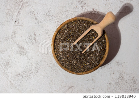 Chia seeds in wooden bowl with wooden spoon. Healthy superfood rich in Omega 3 fatty acids. Dry healthy natural ingredient. Chia grains are falling 119818940