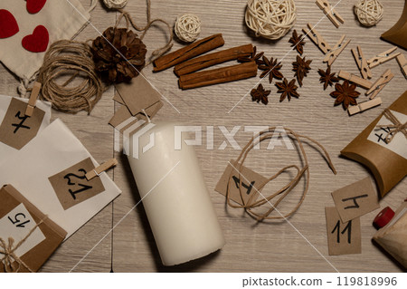 Unrecognizable young woman paint numbers on candles. Female making homemade advent calendar Made with your own hands step by step DIY crafts do it yourself. Preparation to christmas concept. Seasonal 119818996