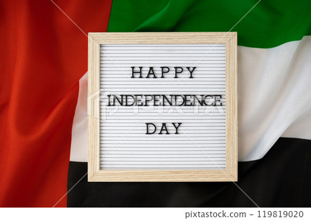 HAPPY INDEPENDENCE DAY text frame on United Arab Emirates waving flag made from silk material. Commemoration Day Muslim Public holiday celebration background. The National Flag of UAE HAPPY INDEPENDENCE DAY text frame on United Arab Emirates waving flag made from silk material. Commemoration Day Muslim Public holiday celebration background. The National Flag of UAE 119819020