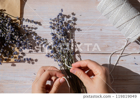 Top view flat lay of process making bouquets of dried lavender flowers. Cotton rope, scissors. Female do homemade herbs bouquet 119819049