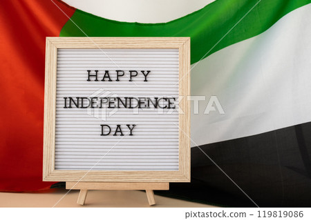 HAPPY INDEPENDENCE DAY text frame on United Arab Emirates waving flag made from silk material. Commemoration Day Muslim Public holiday celebration background. The National Flag of UAE HAPPY INDEPENDENCE DAY text frame on United Arab Emirates waving flag made from silk material. Commemoration Day Muslim Public holiday celebration background. The National Flag of UAE 119819086