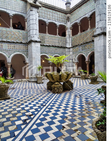 Interior of the arched courtyard with beautifully decorated arches and columns in Arabic style and the yellow painted walls of the Pena Palace in Sintra, Portugal. 119819186