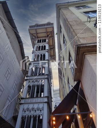 Sun-kissed morning in Lisbon! Iconic Santa Justa Elevator rises against a clear summer sky, captured from the historic Rua Augusta. A picturesque blend of architecture and sunshine. Sun-kissed morning in Lisbon! Iconic Santa Justa Elevator rises against a clear summer sky, captured from the historic Rua Augusta. A picturesque blend of architecture and sunshine. 119819213