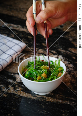 Wakame salad in a bowl and bamboo sticks Wakame salad in a bowl and bamboo sticks 119820655