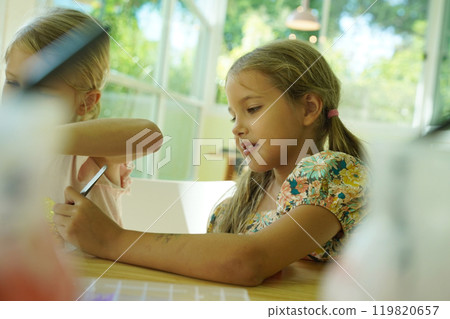 Teacher in workshop teched two girls how to assemble a thermo mosaic Teacher in workshop teched two girls how to assemble a thermo mosaic 119820657