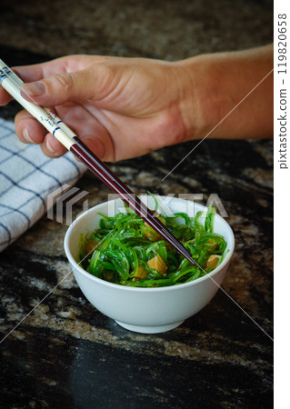 Wakame salad in a bowl and bamboo sticks Wakame salad in a bowl and bamboo sticks 119820658