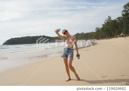 A young woman enjoying a beautiful day at the beach A young woman enjoying a beautiful day at the beach 119820682