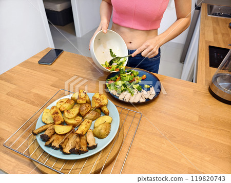 A young woman prepares a fresh meal A young woman prepares a fresh meal 119820743