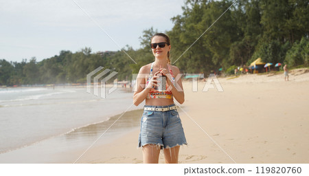 A young woman enjoying a beautiful day at the beach A young woman enjoying a beautiful day at the beach 119820760