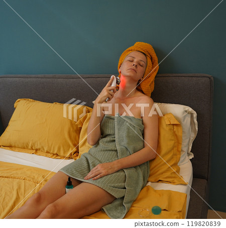 Young woman using infrared massager  119820839