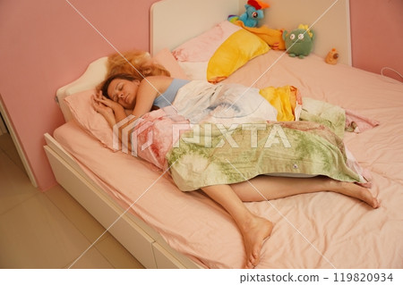 A young woman is enjoying a wonderfully serene morning in her bedroomnd A young woman is enjoying a wonderfully serene morning in her bedroomnd 119820934