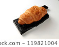 Crispy hot croissant on a black rectangular wooden board on a white background 119821004