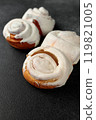 Fragrant Cinnabons with cream on a gray background 119821005