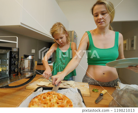 Cooking moments together with mother and daughter at the kitchen 119821013