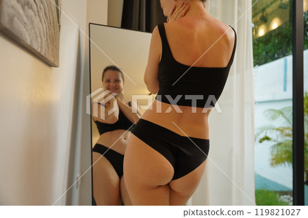 A young woman is enjoying a wonderfully serene morning in her bedroomnd  119821027