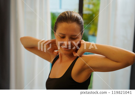 A young woman is enjoying a wonderfully serene morning in her bedroomnd  119821041