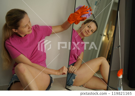 A woman is cleaning her living room at home A woman is cleaning her living room at home 119821165
