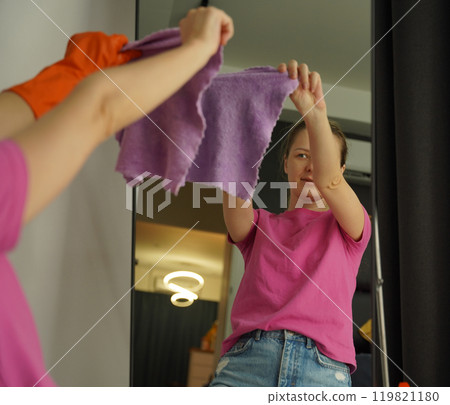 A woman is cleaning her living room at home 119821180