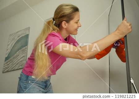 A woman is cleaning her living room at home A woman is cleaning her living room at home 119821225