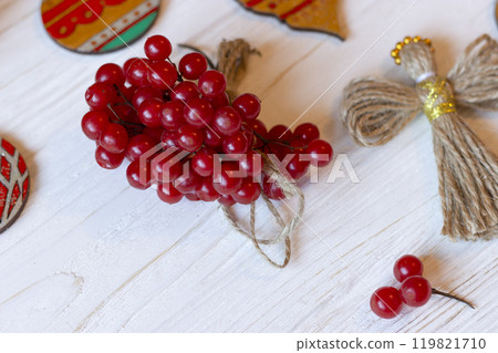 DIY decorations for Christmas. Rural style Christmas with eco-conscious details: snowball tree, cones and wooden handmade decorations for the Xmas tree on pine branches. New Year natural wooden toys. 119821710