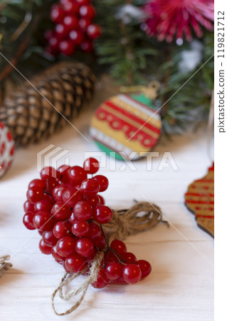 DIY decorations for Christmas. Rural style Christmas with eco-conscious details: snowball tree, cones and wooden handmade decorations for the Xmas tree on pine branches. New Year natural wooden toys. DIY decorations for Christmas. Rural style Christmas with eco-conscious details: snowball tree, cones and wooden handmade decorations for the Xmas tree on pine branches. New Year natural wooden toys. 119821712