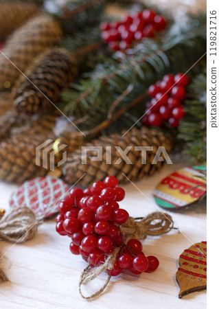 DIY decorations for Christmas. Rural style Christmas with eco-conscious details: snowball tree, cones and wooden handmade decorations for the Xmas tree on pine branches. New Year natural wooden toys. DIY decorations for Christmas. Rural style Christmas with eco-conscious details: snowball tree, cones and wooden handmade decorations for the Xmas tree on pine branches. New Year natural wooden toys. 119821716
