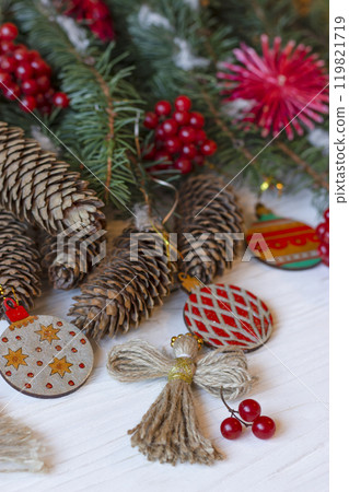 DIY decorations for Christmas. Xmas ornaments. Christmas composition with Ukrainian doll-motanka, wood balls, snowball tree, cones and fir branches. New Year eco-conscious handmade toys. Happy holiday 119821719