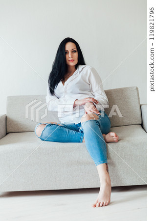 Beautiful brunette woman in home clothes on the sofa Beautiful brunette woman in home clothes on the sofa 119821796