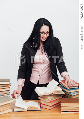 A woman teacher, a librarian and many stacks of books to read 119821801